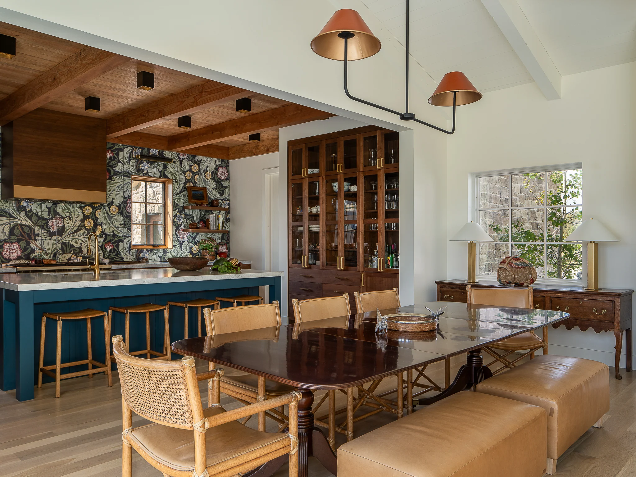 Open dining area beneath a wood beam ceiling with copper pendant lights — interior design photography Driggs Idaho, River's Edge